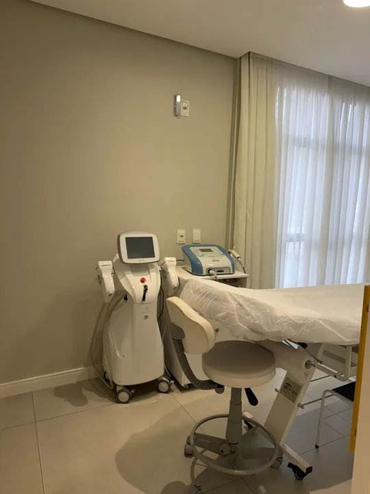 Sala de procedimentos da Harmonelle Clínica, com maca e equipamento