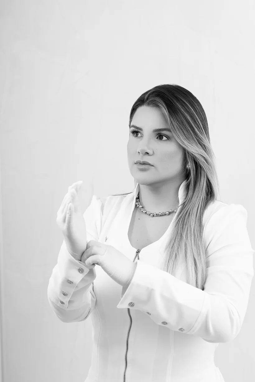 Dra. Manu Maia calçando as luvas antes de um procedimento