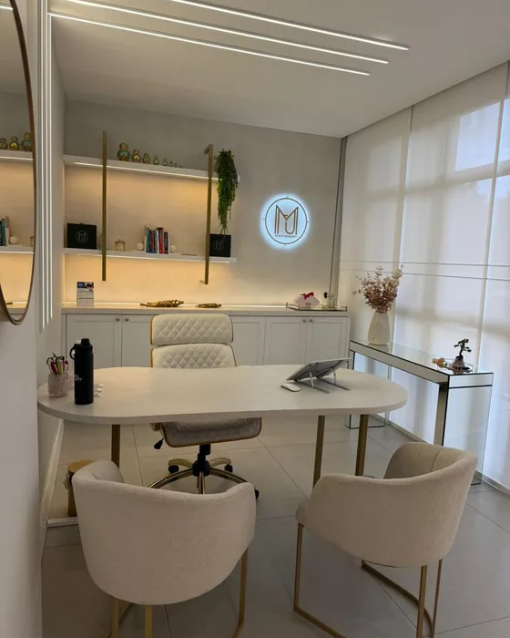 Consultório de avaliação da Harmonelle Clínica, com mesa e poltronas
