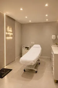 Sala de procedimentos da Harmonelle Clínica, com maca e iluminação suave