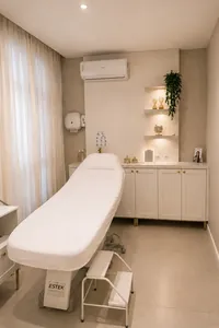Sala de atendimento da Harmonelle Clínica, com maca, armários claros e cortina na janela